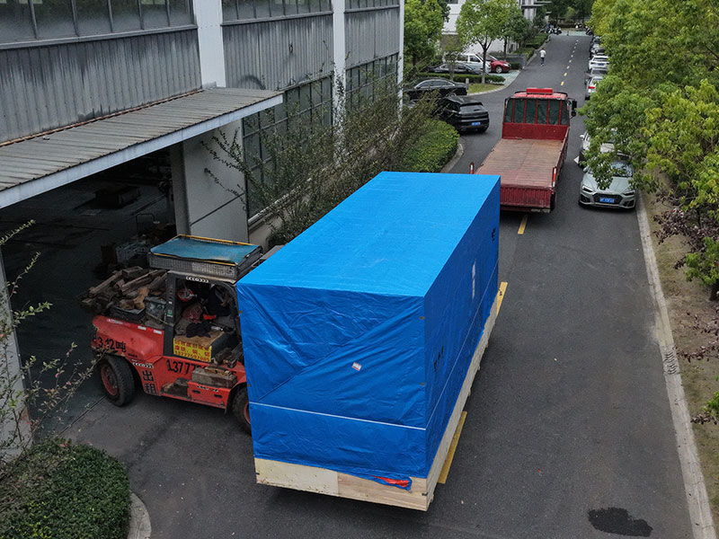 叉车正在将打包好木箱及包裹好三防布的组合式制氮机装车